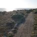 Wheelchair tracks along a fine gravel clifftop path near the ocean.